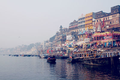 Boats in sea against buildings in city