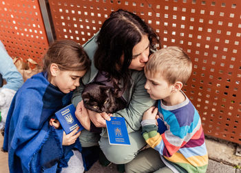 Mother with children and cat holding passports fleeing from ukraine waiting for help registration