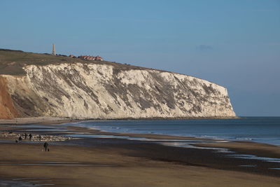 Scenic view of rocks on beach against sky