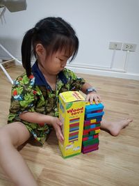 Boy playing with toy on floor at home