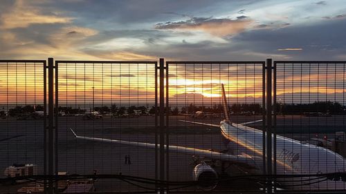 Scenic view of sunset seen through fence