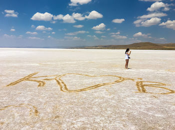 Full length of woman standing on land against sky