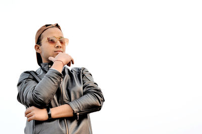 Portrait of young man looking away against white background