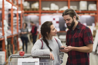 Couple using smart phone in hardware store