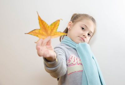 Young girl holding autumn leaf