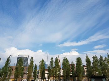 Low angle view of trees and buildings against sky