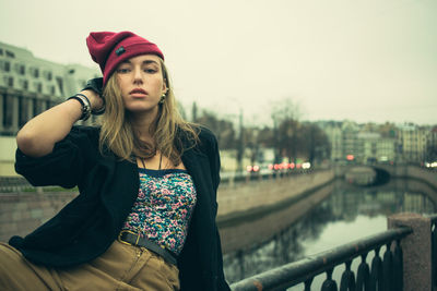 Portrait of young woman sitting on wall