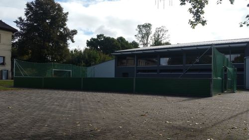 House by trees against sky in city