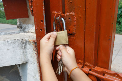 Close-up of human hand on metal door