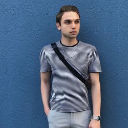 Handsome young man standing against wall