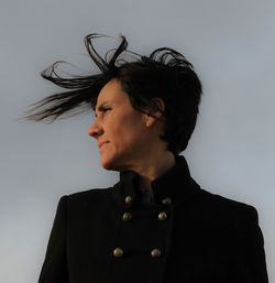 Mature woman standing against clear sky