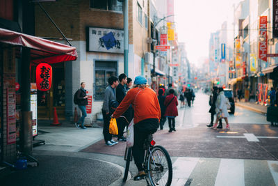 People walking on road along buildings