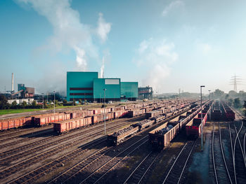 Shunting yard in city against sky
