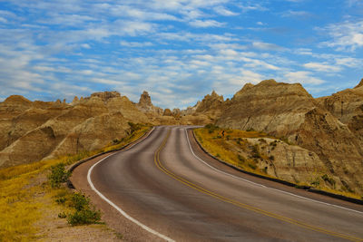 Scenic view of road amidst mountains against sky