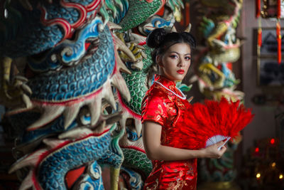 Full length of young woman standing against multi colored background