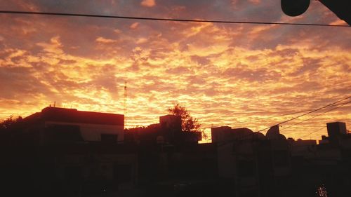 Silhouette cityscape against sky during sunset