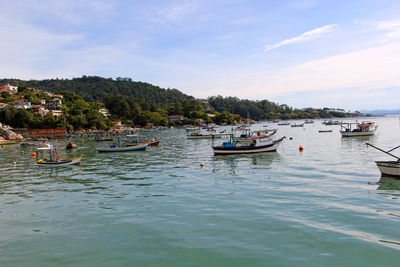 Boats moored in sea against sky