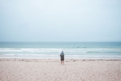 Rear view of man standing on beach