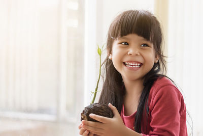 Portrait of smiling girl holding indoors