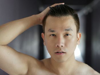 Portrait of shirtless man with hand in hair