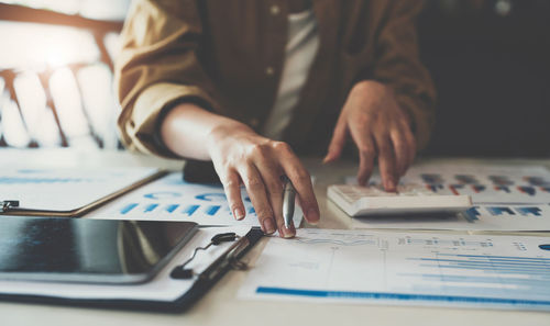 Midsection of businessman working at desk in office