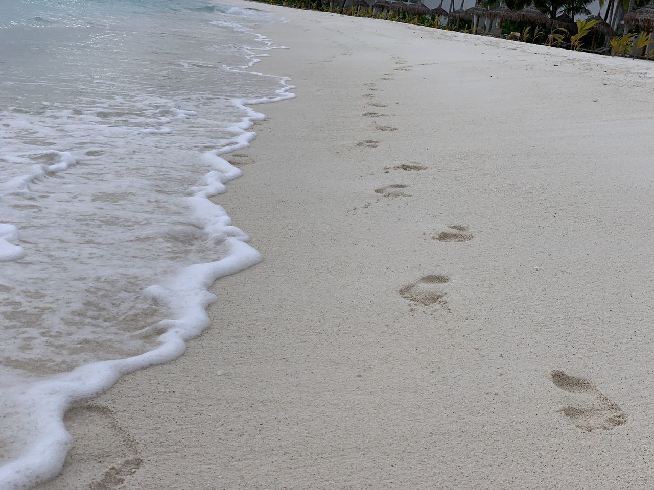 HIGH ANGLE VIEW OF FOOTPRINT ON BEACH