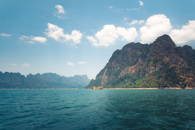 Scenic view of sea and mountains against sky