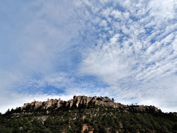 Low angle view of rocks on mountain against sky