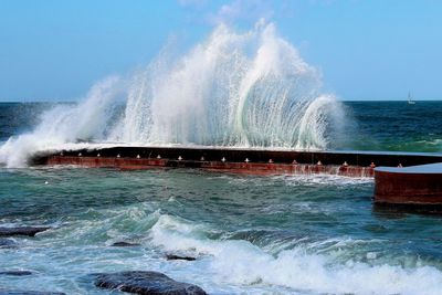 Water splashing in sea against clear sky