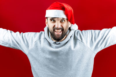 Portrait of mid adult man wearing hat against red background