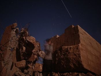 Low angle view of rock formation against sky at night