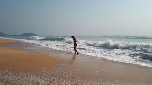Full length of woman on beach against sky
