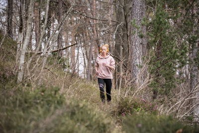 Full length of woman running in forest