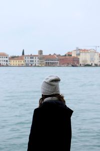 Rear view of girl looking at river against clear sky