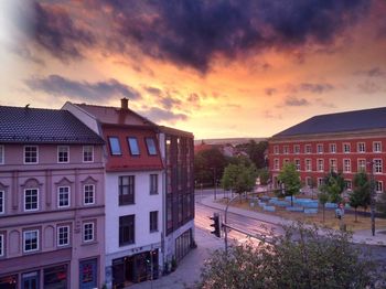 Buildings against cloudy sky at sunset