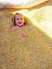 Portrait of happy girl lying under corn kernel