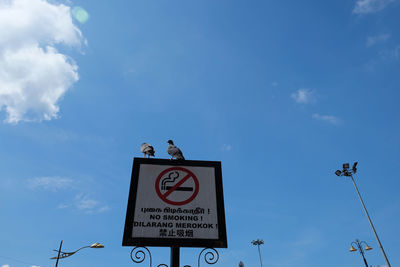 Low angle view of road sign against sky