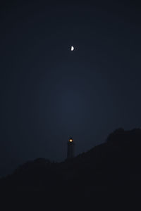 Low angle view of lighthouse against sky at night