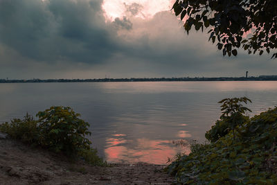 Scenic view of lake against sky at sunset