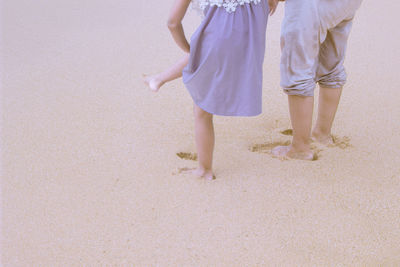 Low section of people on sand at beach