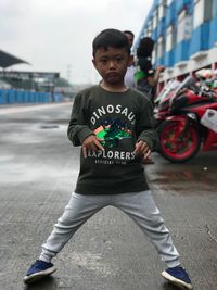 Full length of boy standing on road in city