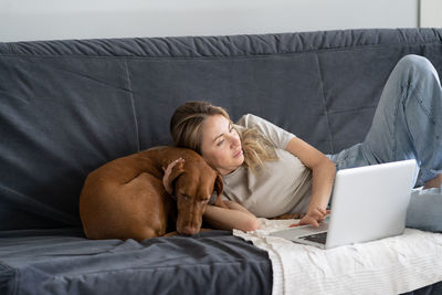 Young man using laptop on sofa at home