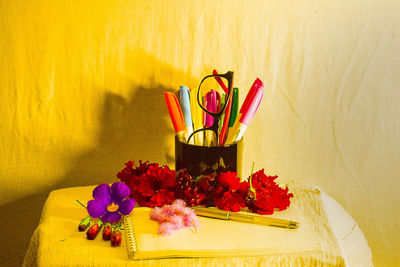 Close-up of flower pot on table against wall