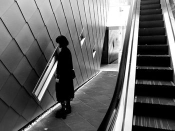 Full length of woman standing on tiled floor by wall