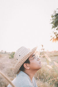 Side view of woman looking away against sky