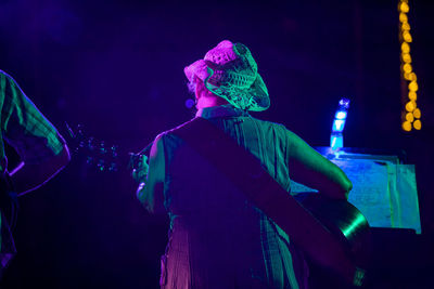 Midsection of man with illuminated lights at night