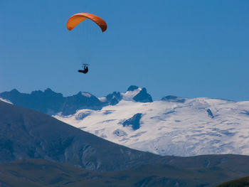 Person paragliding against sky