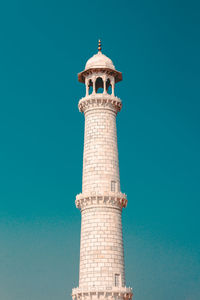 Low angle view of minaret against clear blue sky