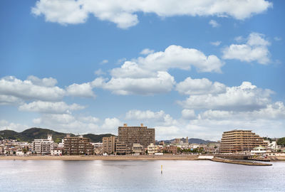 Buildings by sea against sky in city