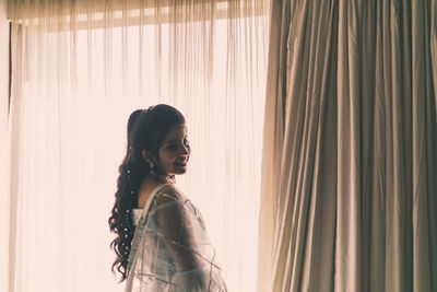 Side view of young woman looking at camera 